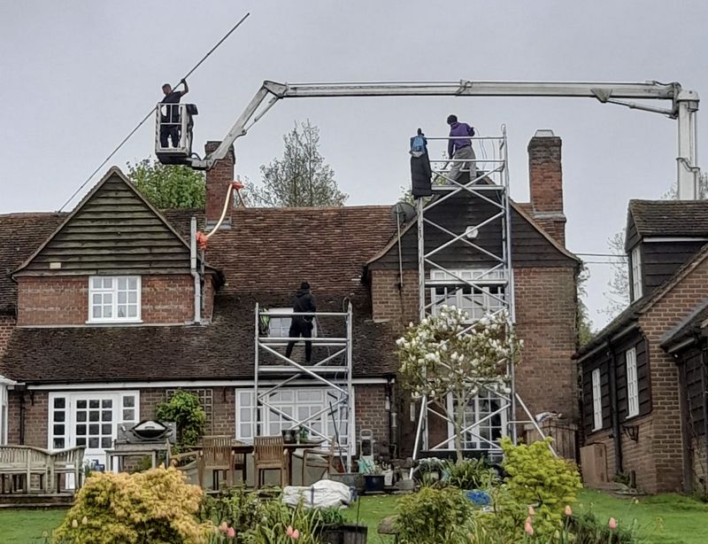 The Roof Moss Cleaners using cherry picker and scaffolding to clean roof safely and professionally in West Clandon, Surrey