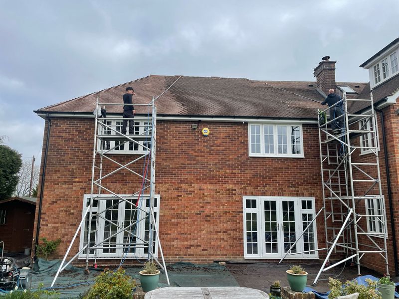 Roof cleaning carried out safely from scaffold towers by The Roof Moss Cleaners in West Clandon